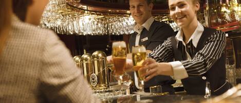 A bar setting with a bartender and a customer.