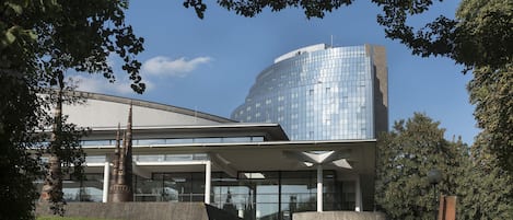 Un edificio moderno con fachada de vidrio, techo plano y un amplio espacio de entrada.