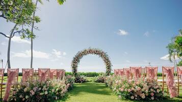 An outdoor wedding aisle with floral decorations and chairs.