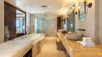 A modern bathroom with a large bathtub, a double sink, and a large mirror.