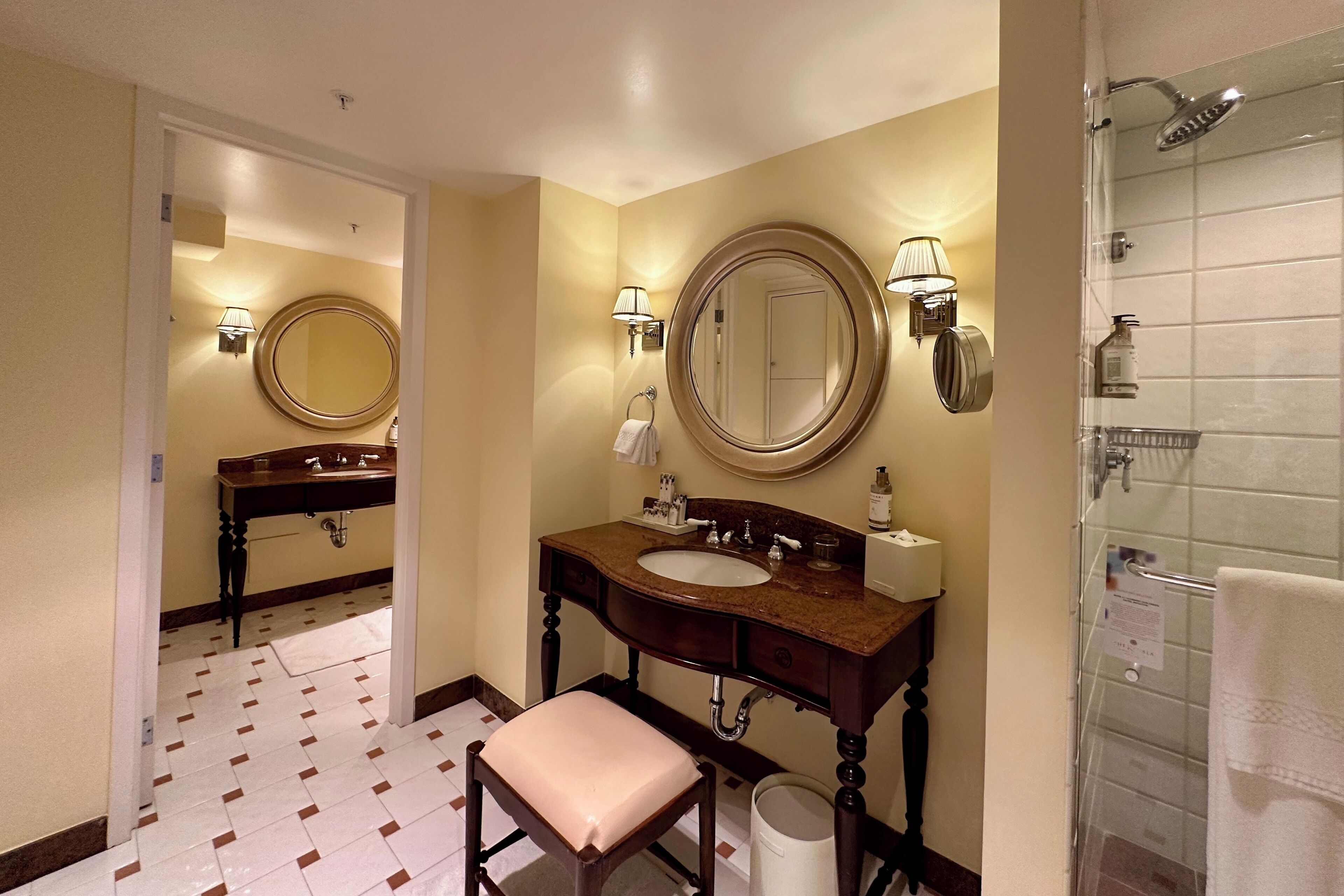 Een badkamer met een wastafel, spiegel, wastafelmeubel en douche.