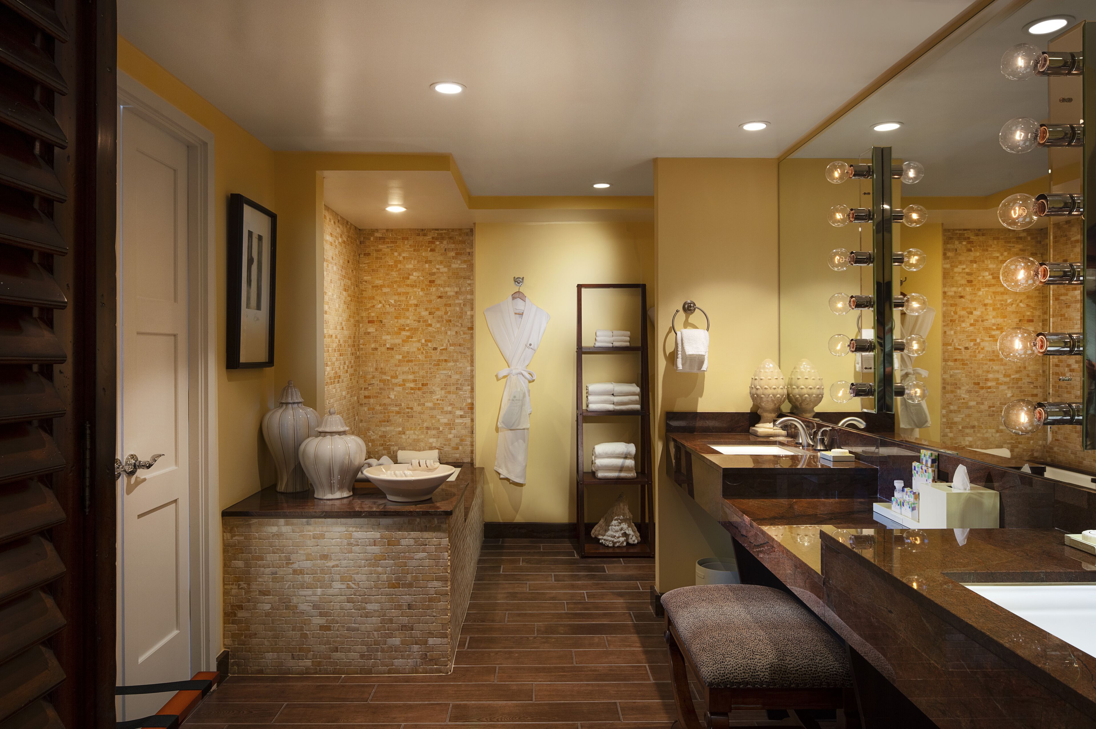 A modern bathroom with a large mirror, multiple sinks, and a vanity area.