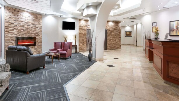 Een moderne lobby met een open haard, zithoek en een receptiebalie.