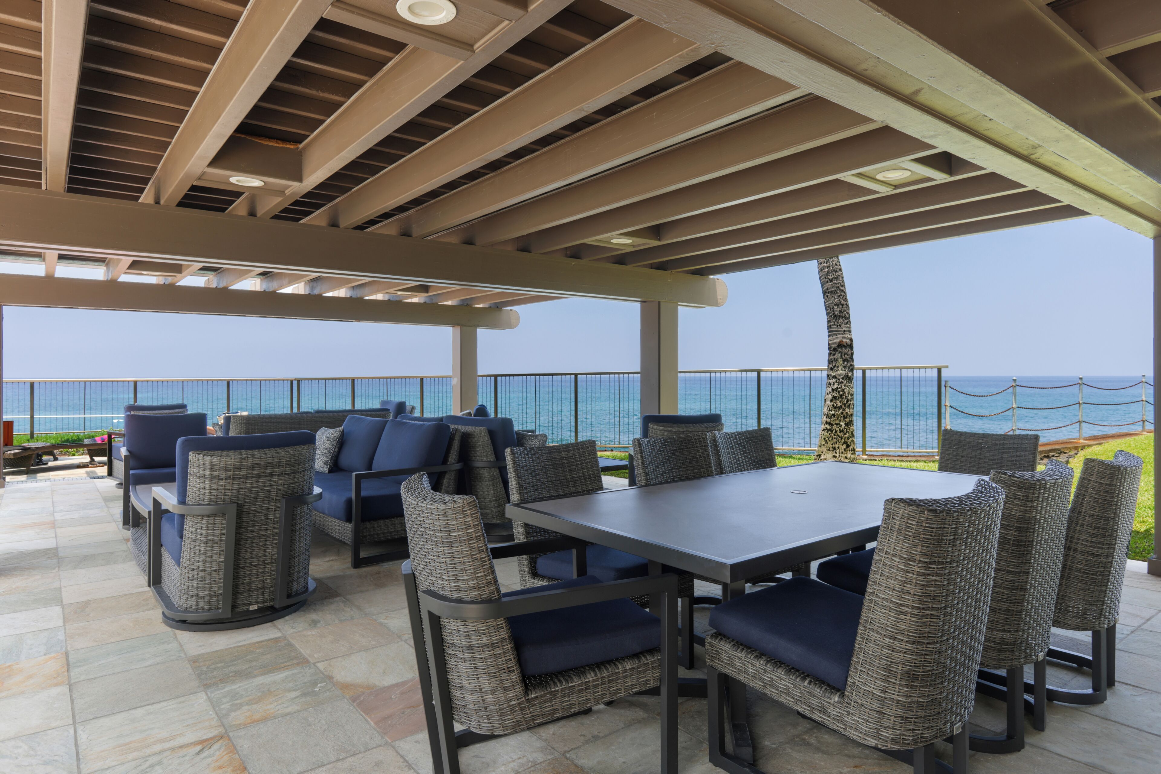 An outdoor patio with a table and chairs, overlooking a body of water.