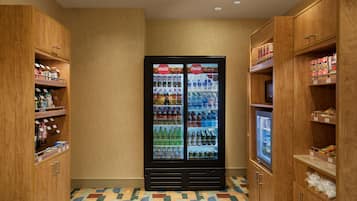 Ein Hotelzimmer mit Holzausstattung, einem gemusterten Boden und einem Coca-Cola Kühlschrank.