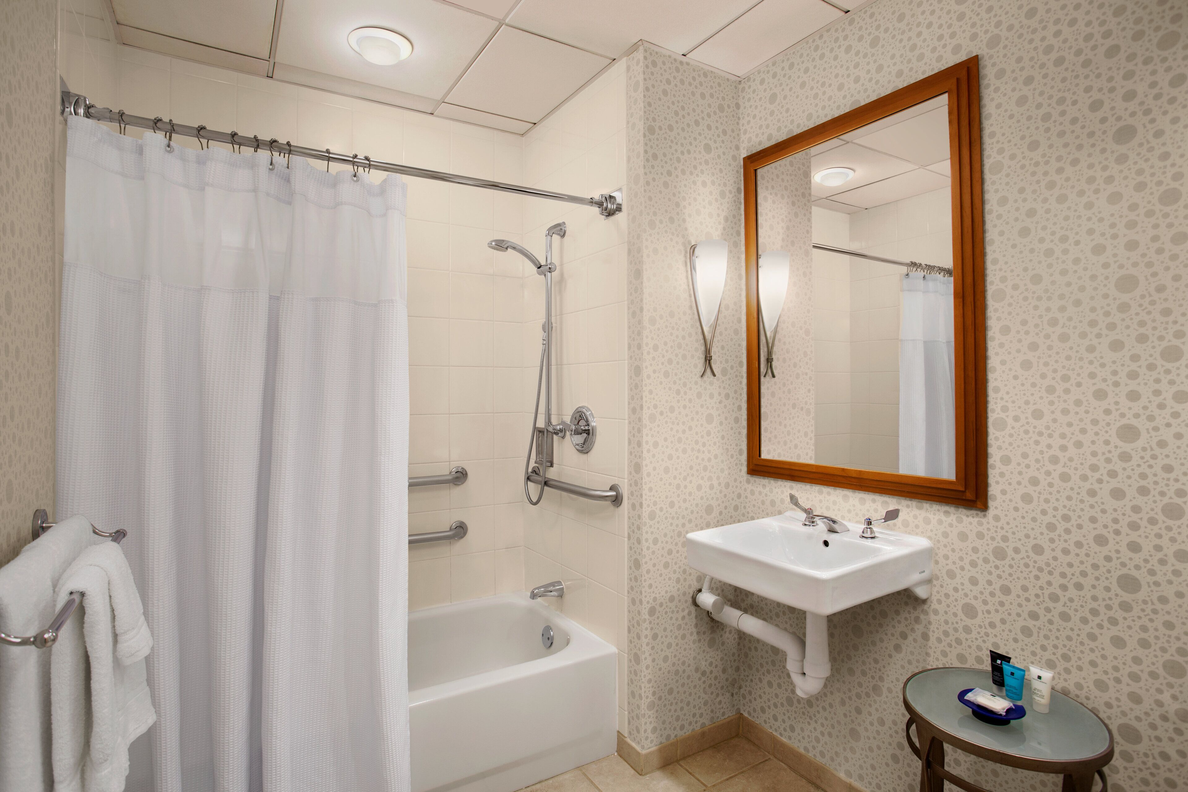 A bathroom with a shower, a bathtub, a sink, and a mirror.