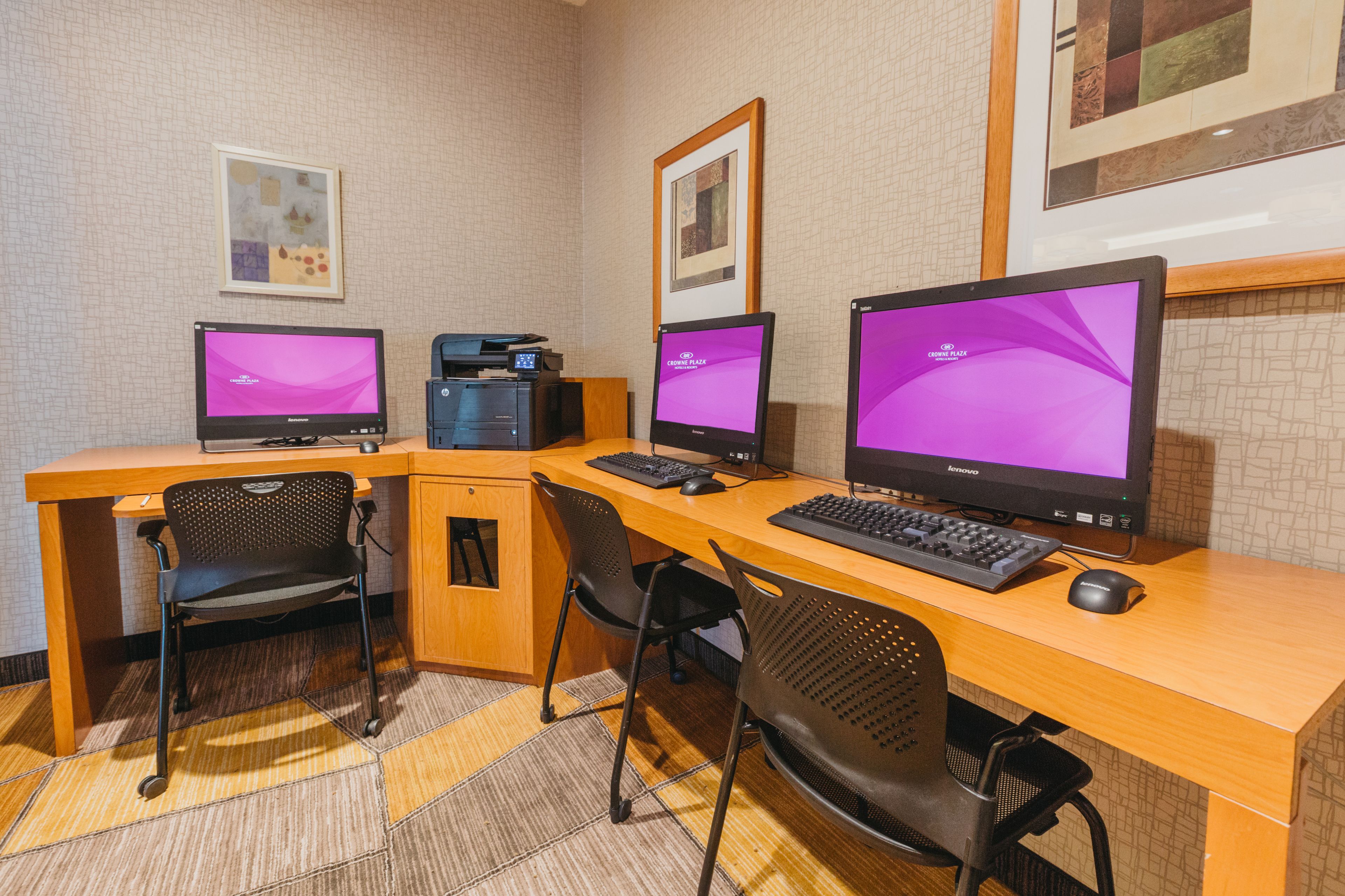Un espacio de trabajo con dos monitores, un teclado y dos sillas.
