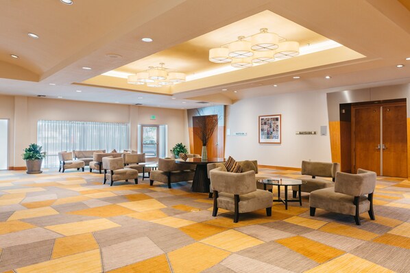 A spacious lobby with a checkered floor, multiple seating areas, and a large wooden door. - Crowne Plaza San Francisco Airport by IHG (Burlingame)