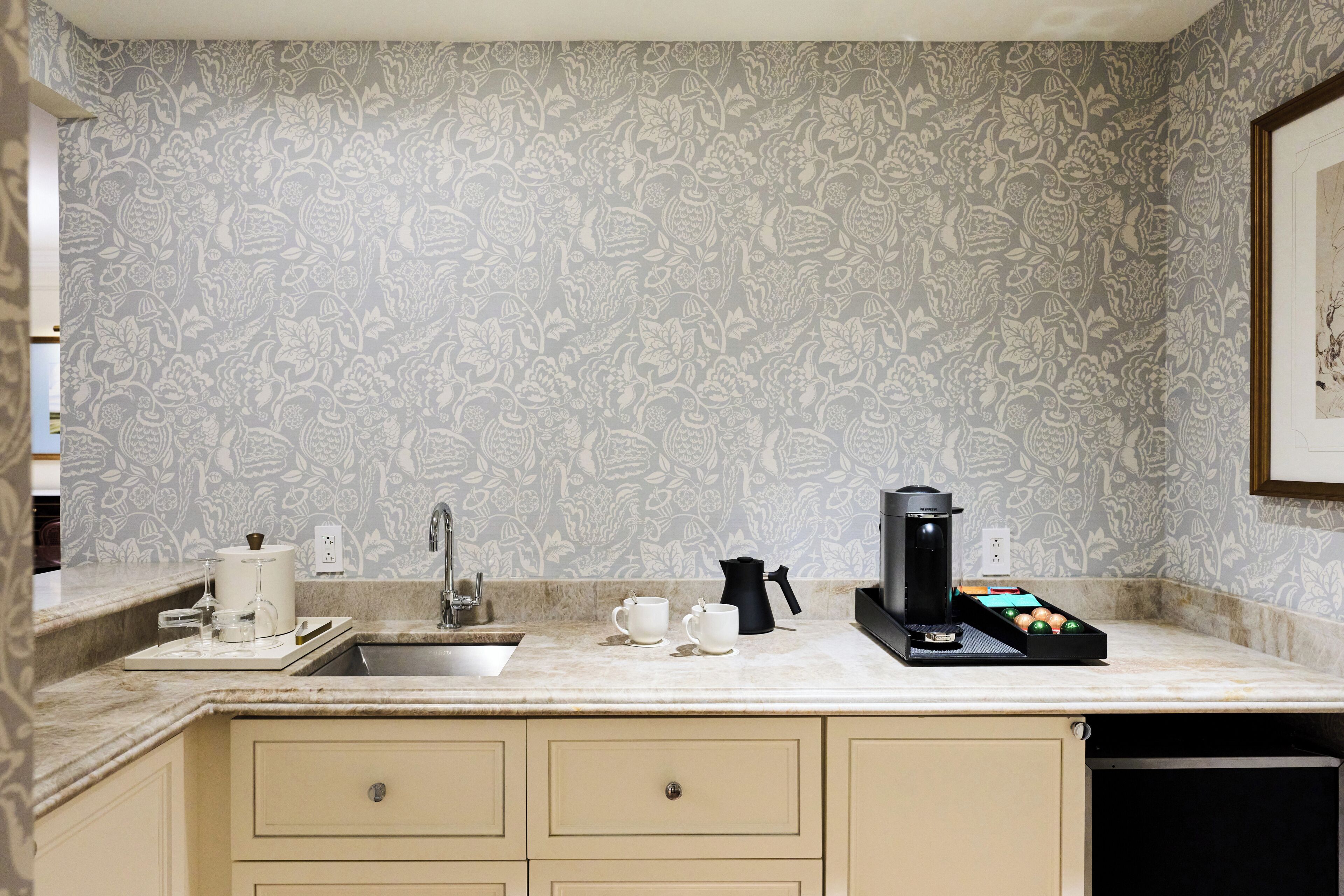 A kitchen with a sink, countertop, and cabinets.