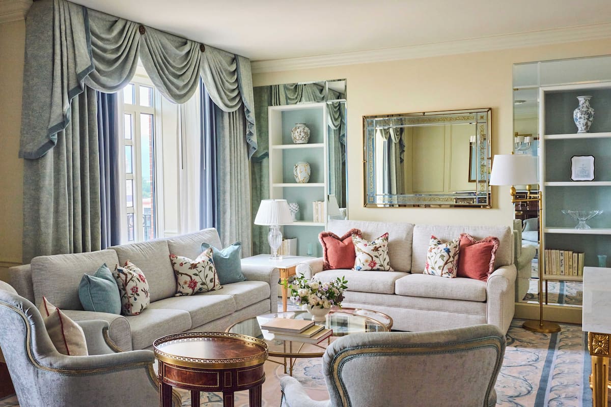 A well-appointed living room with two sofas, a coffee table, and a bookshelf.