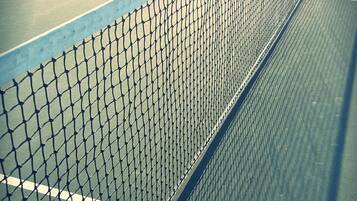 A tennis court with a net and lines.