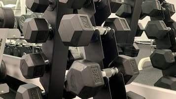 A rack of 10KG dumbbells in a gym setting.