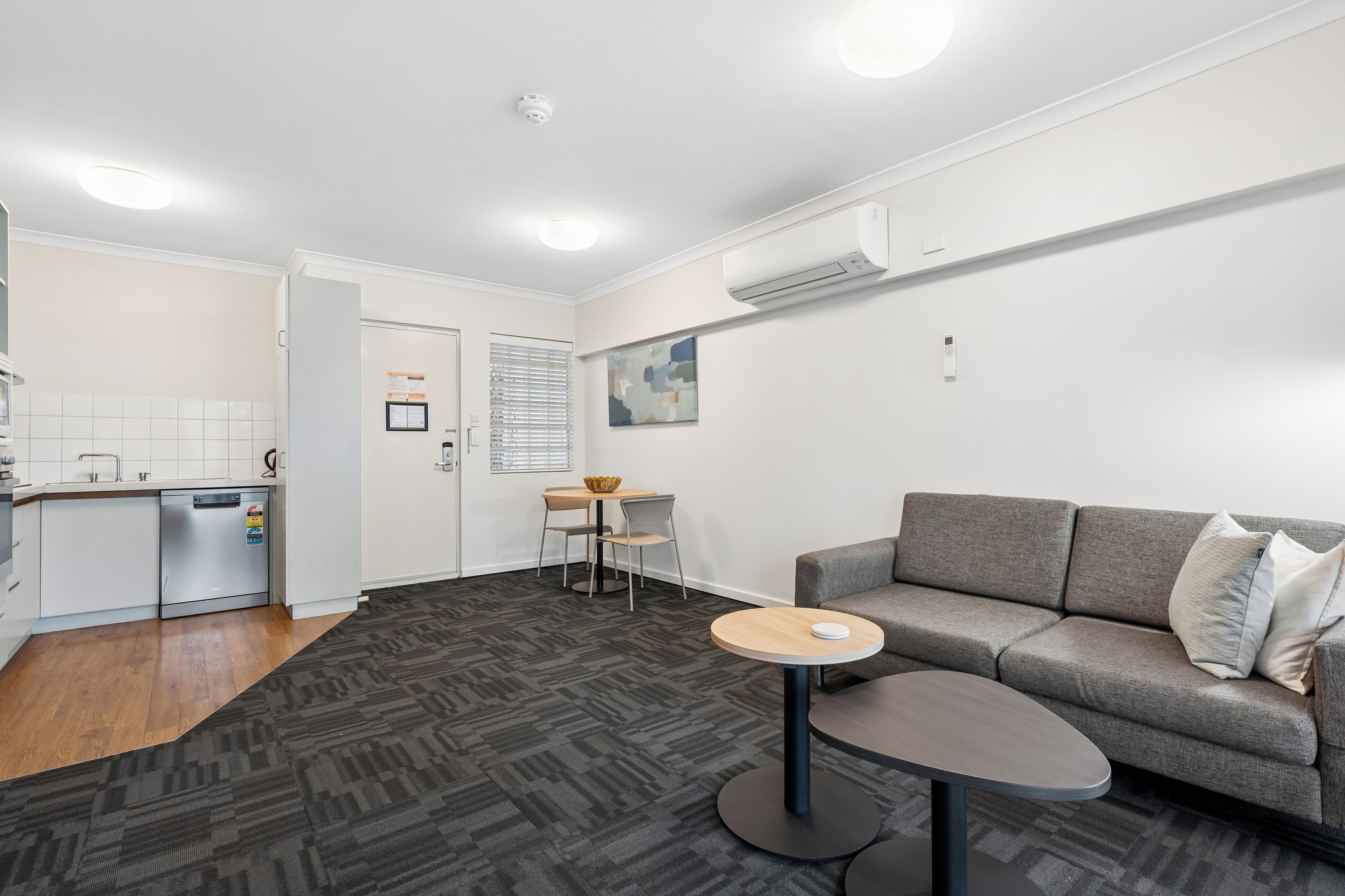 A modern living room with a grey sofa, a round coffee table, and a small side table.