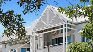 A modern building with a white exterior, a balcony with a white railing, and a staircase leading to an upper level. - Broadwater Resort Como (Como)