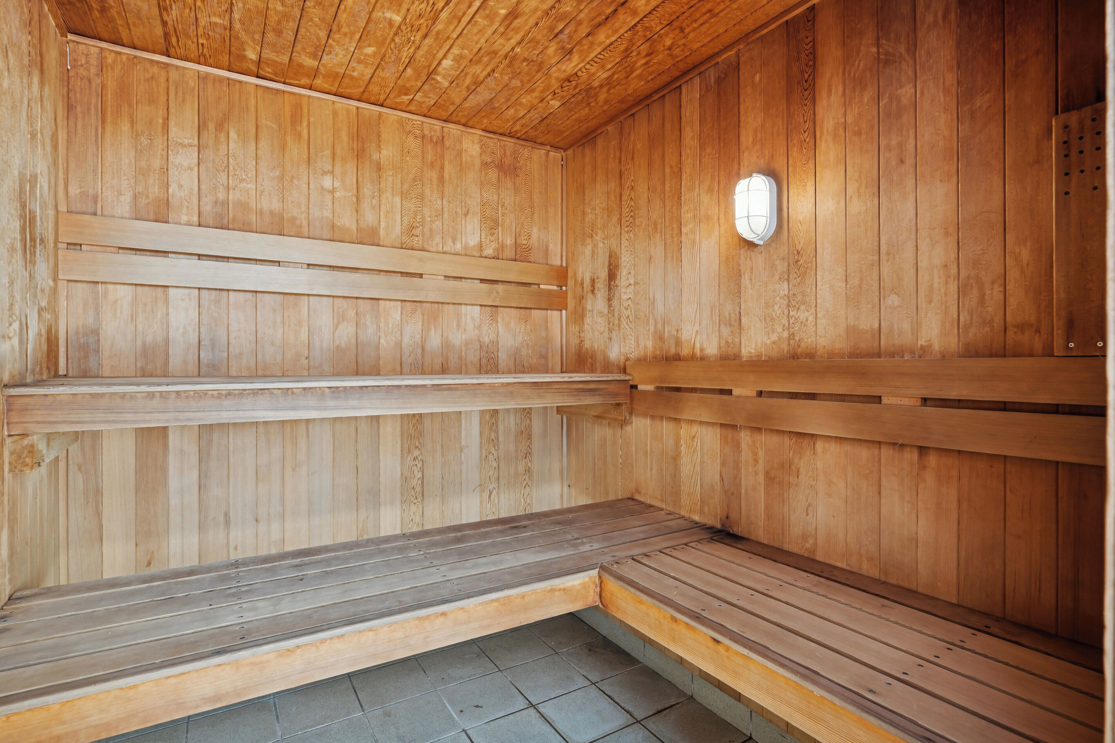A sauna with wooden benches and a tiled floor.