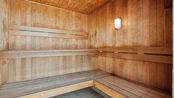 A sauna with wooden benches and a tiled floor.