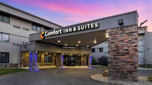 A Comfort Inn & Suites building with a stone facade, multiple entry points, and a clear sky. - Comfort Inn & Suites Indianapolis Northwest - College Park (Indianapolis)