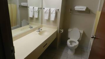 A bathroom with a sink, mirror, toilet, and towel rack.