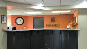 Una reception con una sveglia, una insegna che recita 'Haven' e un rilevatore di fumo a parete.