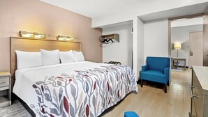 Une chambre d’hôtel comprenant un lit, des lampes de chevet, une chaise, un bureau et une armoire.