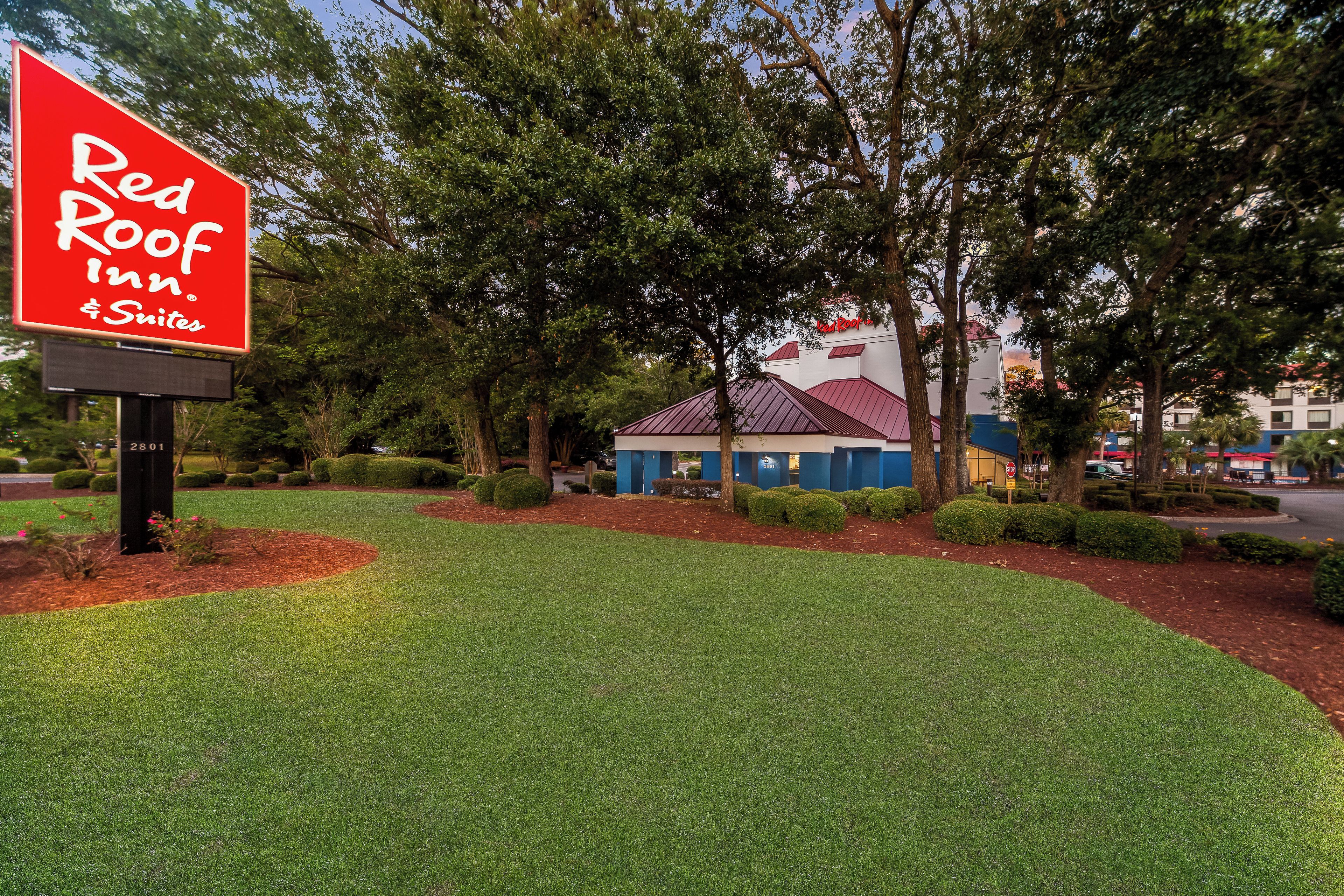 A Red Roof Inn & Suites sign with a building in the background.