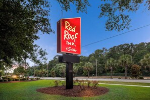A Red Roof Inn sign with a clear sky and trees in the background. - Red Roof Inn Myrtle Beach Hotel - Market Common (Myrtle Beach)