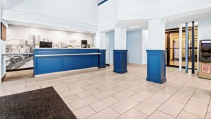 Un hall d’hôtel doté d’un comptoir d’accueil, d’une fresque représentant un paysage urbain et d’un design moderne.
