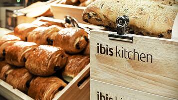 Wooden display cases labeled "ibis kitchen" containing various baked goods.