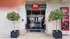 The exterior of the ibis Lisbon Malhoa hotel with a clear glass entrance, a 'Clean Key' sign, and a 'Welcome' mat. - ibis Lisboa José Malhoa (Lisbon)