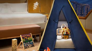 Cozy retreat with a made bed, play area, and a fun tent for kids.