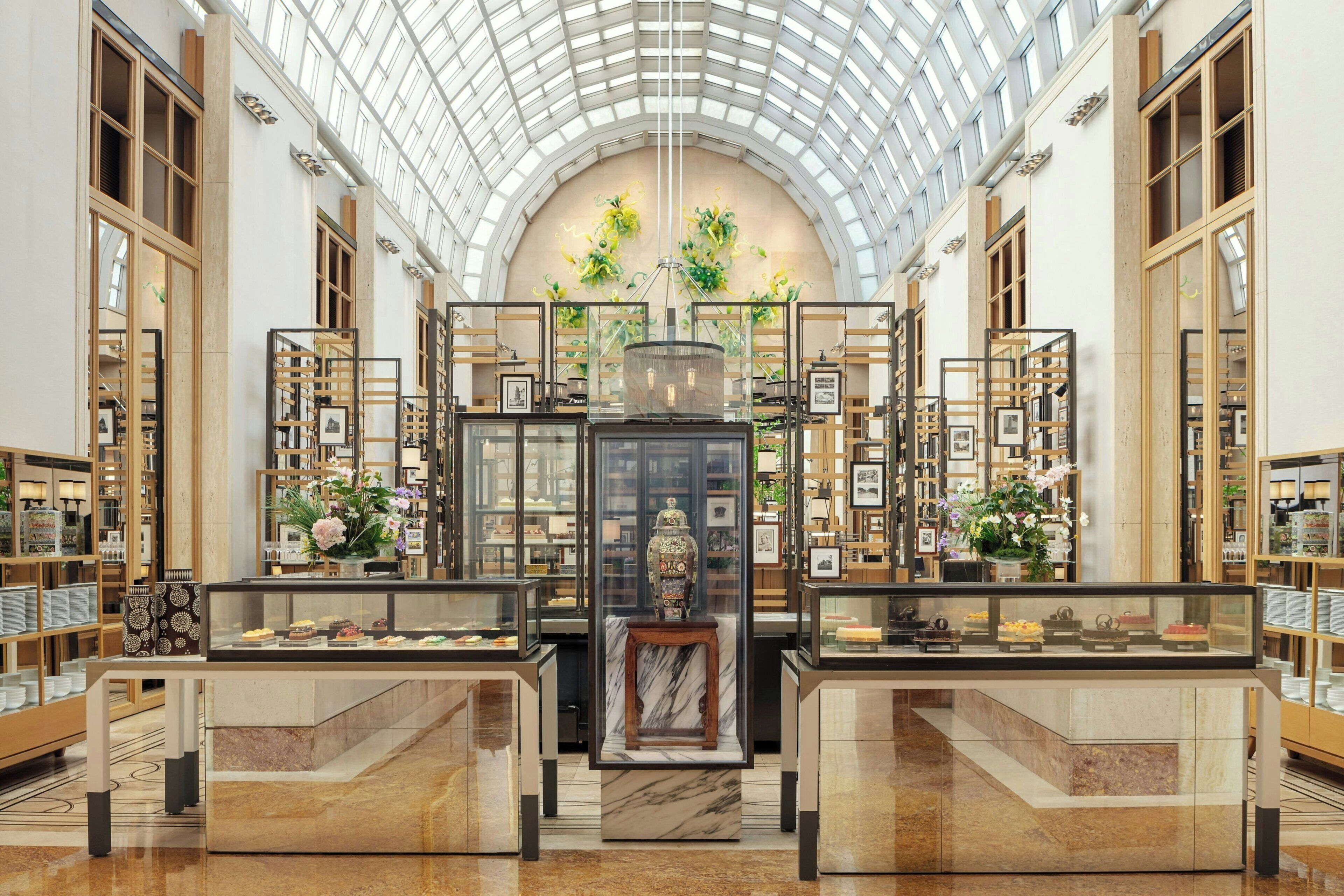 A spacious atrium with a high ceiling and skylights, featuring display cases with various items and a central decorative piece.