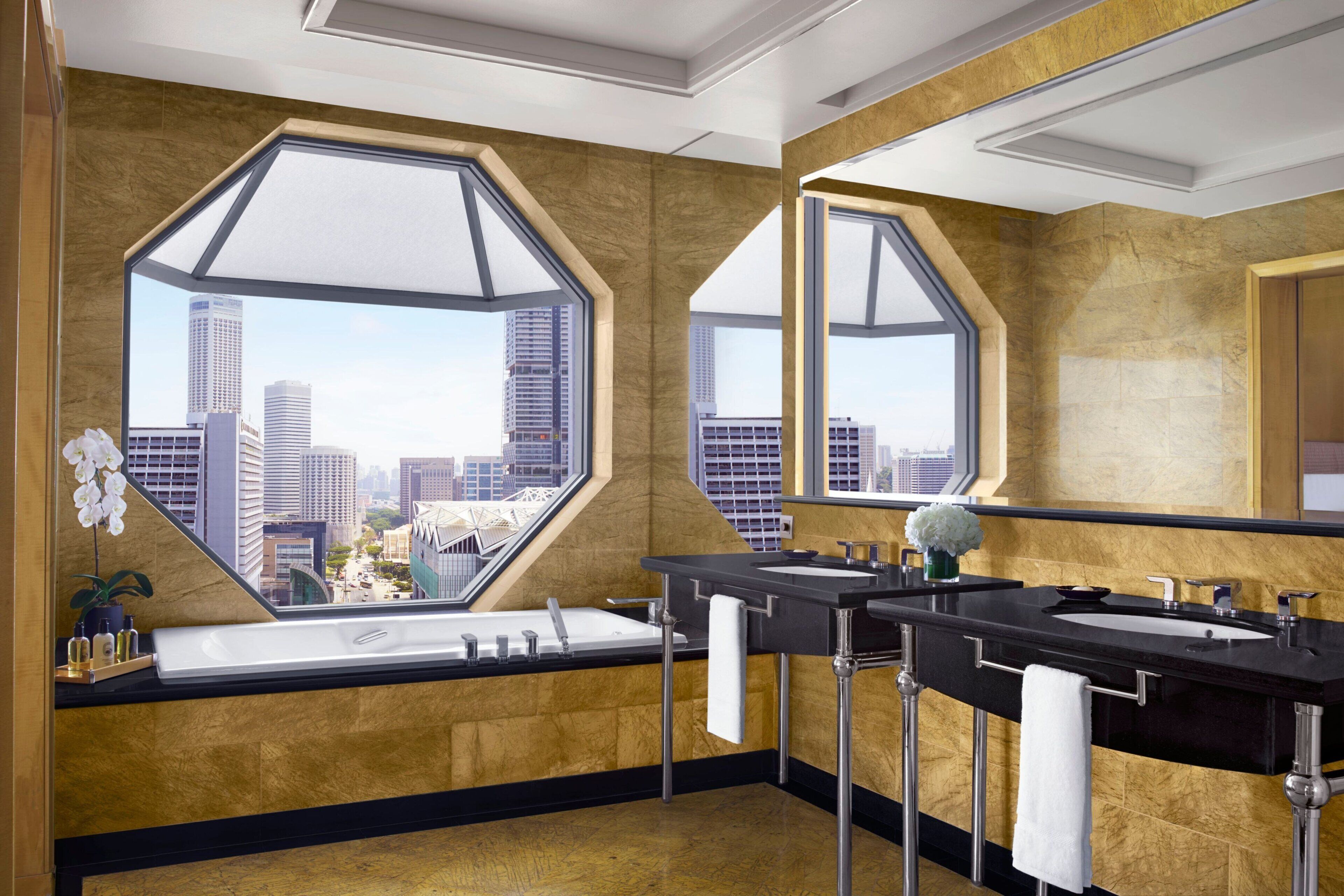A modern bathroom with a large window, two sinks, and a bathtub.