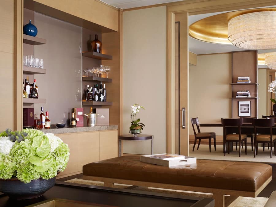 A modern hotel lobby with a bar area, seating, and a dining space.
