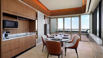 A modern kitchen with a built-in microwave, a coffee machine, and a large window overlooking a balcony.