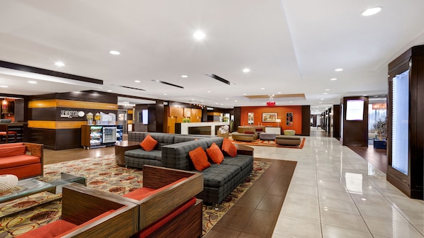A spacious lobby with a reception desk, seating area, and a vending machine.