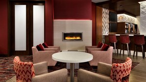 Un vestíbulo moderno con chimenea, zona de estar y bar.