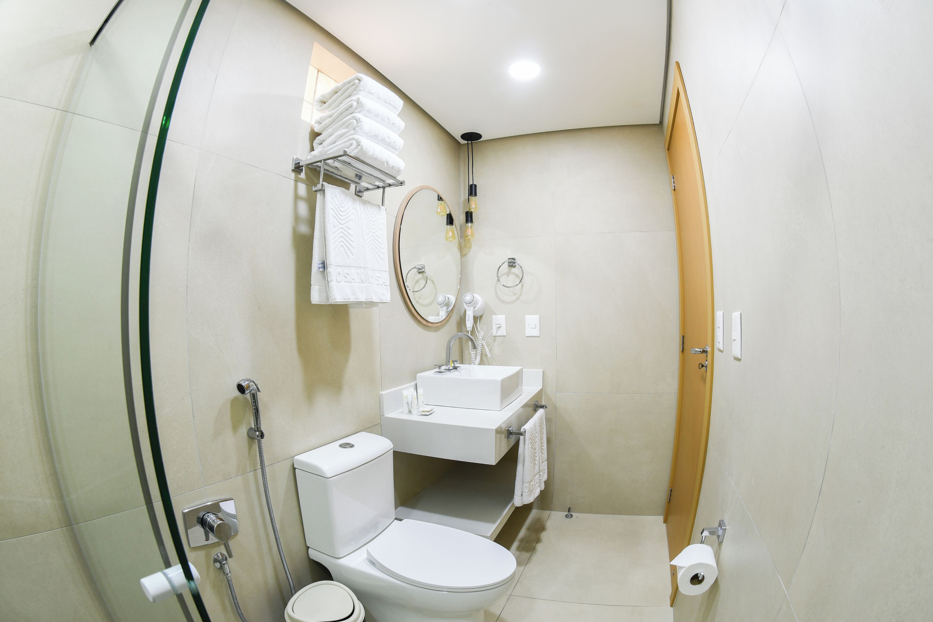 Un baño moderno con inodoro, lavamanos y ducha.