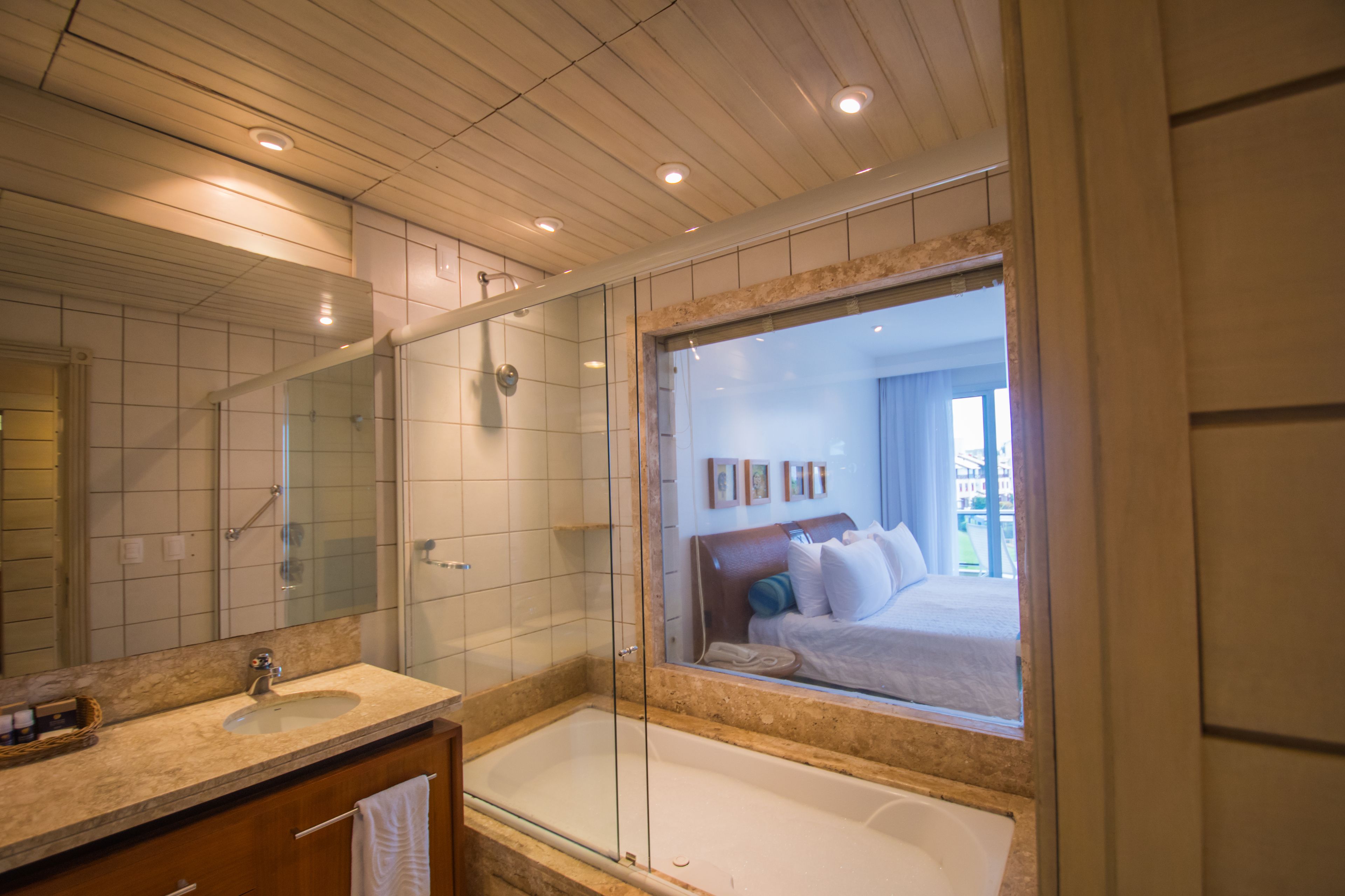 Un baño moderno con ducha de vidrio, un espejo grande y una bañera.