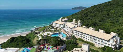 A resort with a large swimming pool, a water park, and a beach.