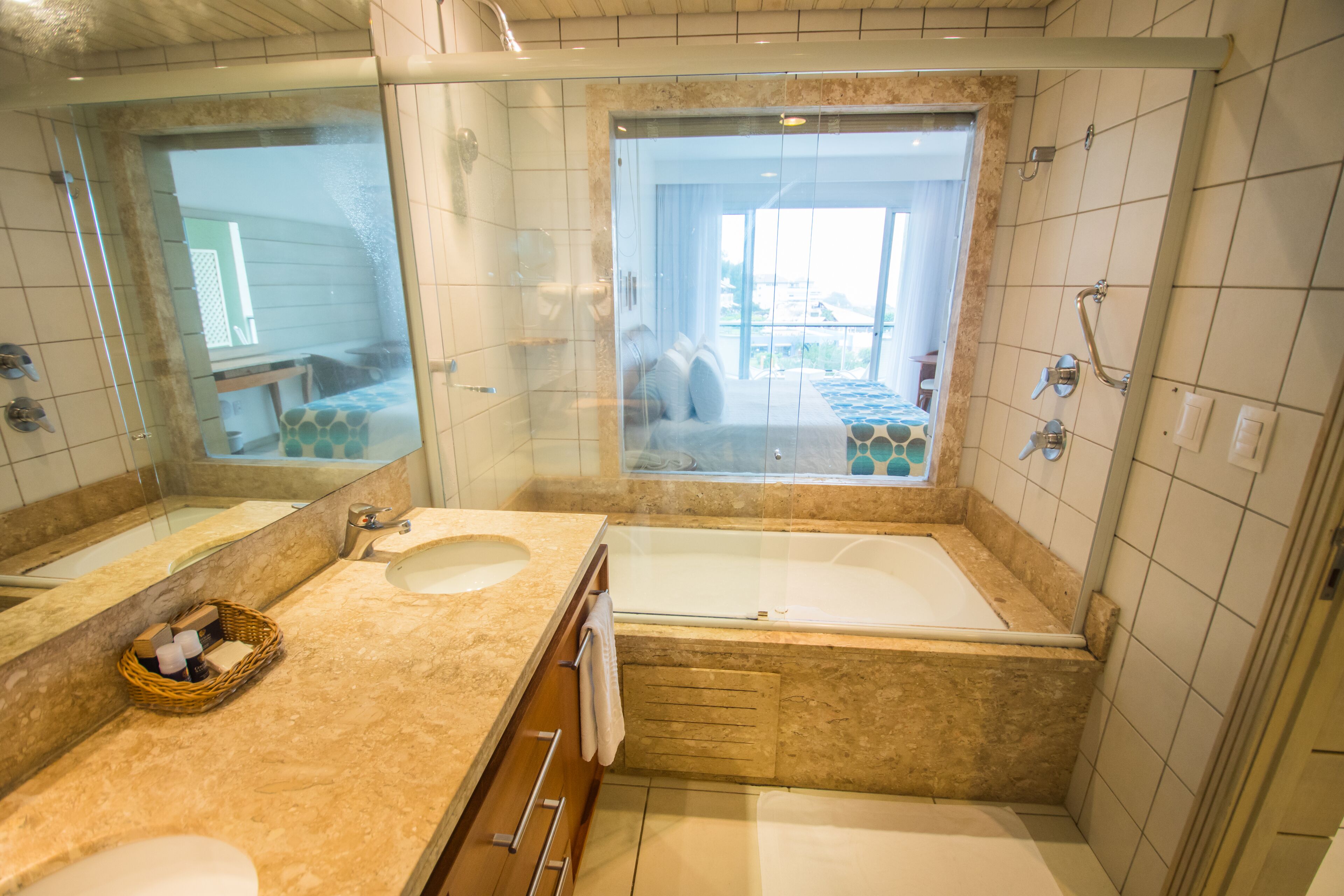 A bathroom with two sinks, a bathtub, and a large mirror.