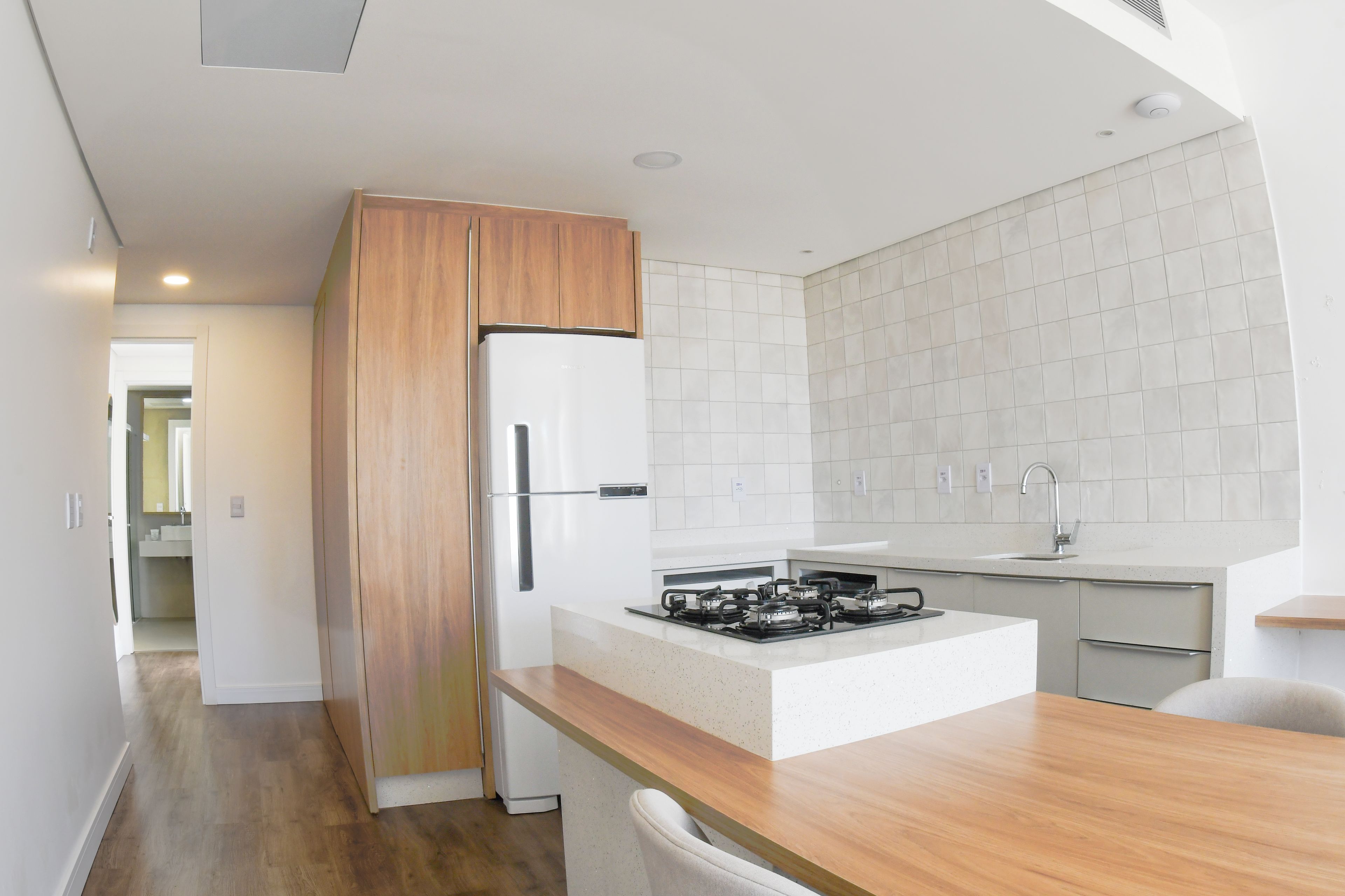 A modern kitchen with a built-in refrigerator, a gas stove, and a wooden countertop.
