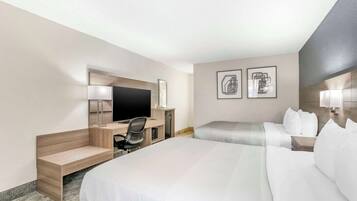 Une chambre d’hôtel avec un grand lit, un bureau avec une chaise, un téléviseur à écran plat et deux tables de chevet.