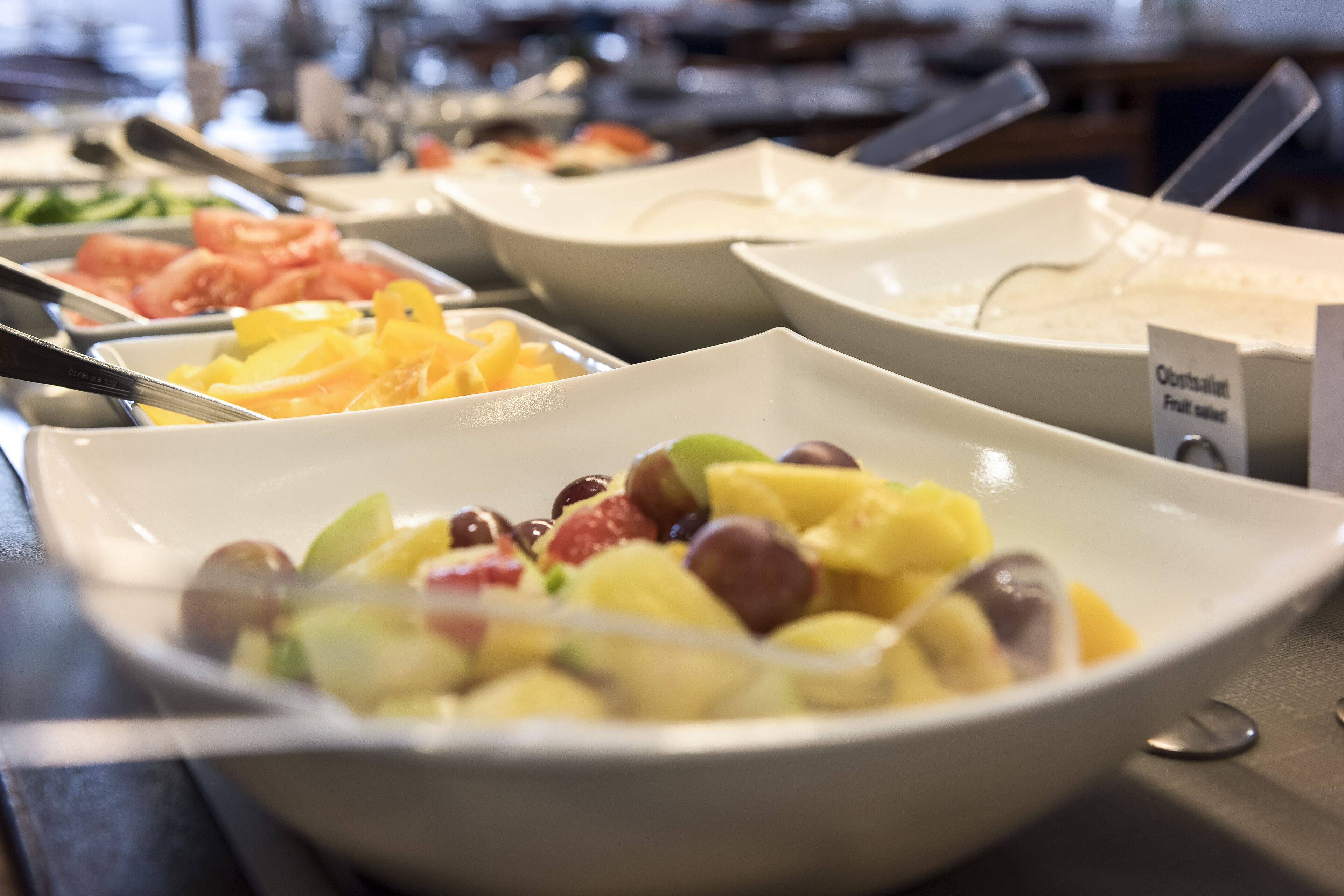 A buffet with various fruit and vegetable dishes.