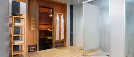Ein modernes Badezimmer mit Holztür, Duschkabine aus Glas und Fliesenboden.
