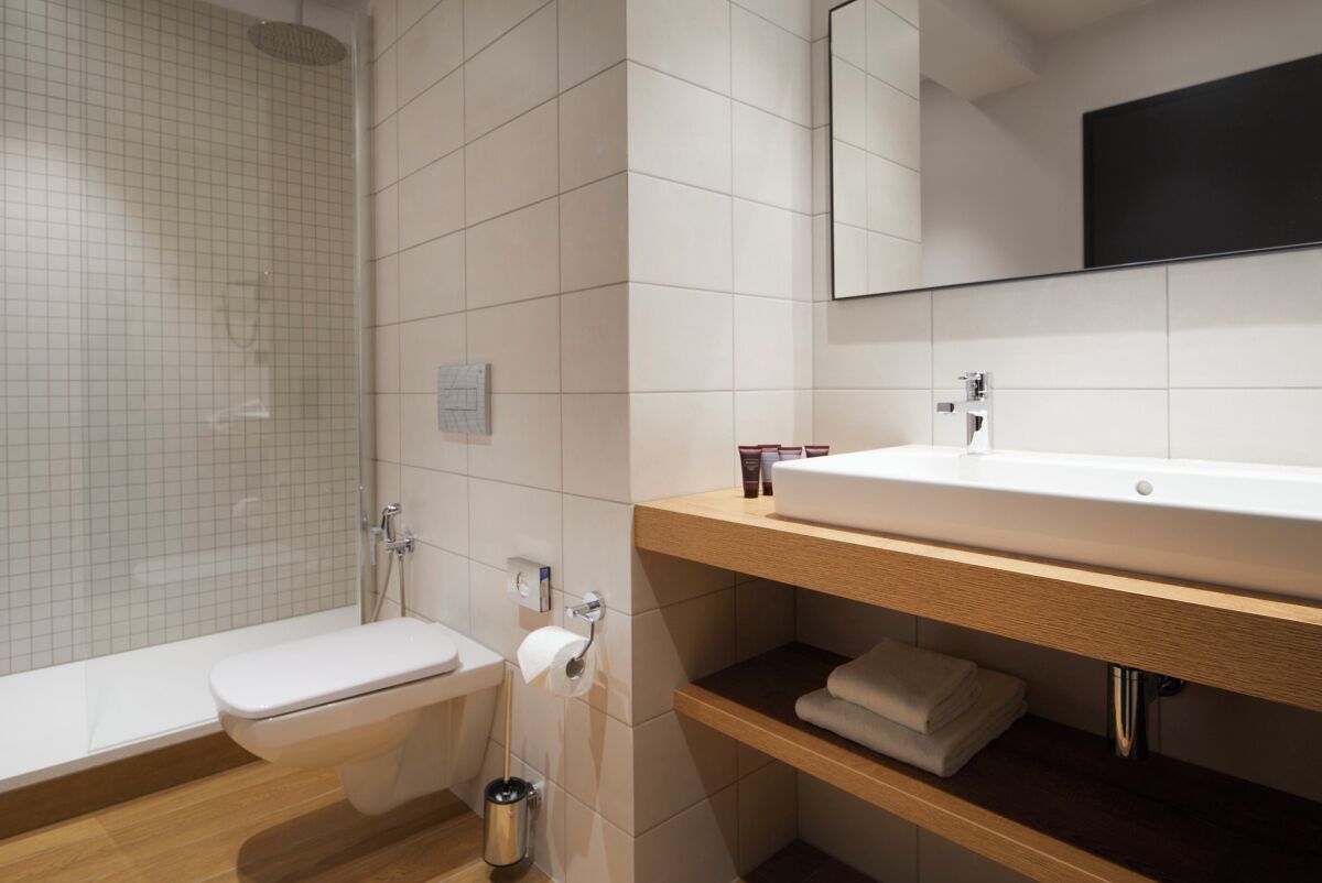 A modern bathroom with a shower, toilet, and sink.