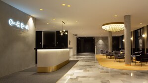 A modern hotel lobby with a reception desk, seating area, and a chandelier. - Orea Congress hotel Brno (Brno)