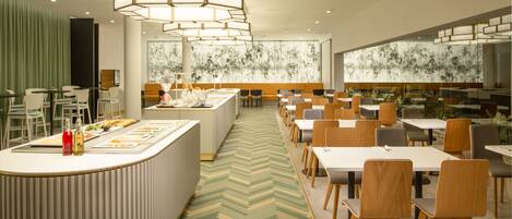 A modern dining area with a central island, multiple tables, and chairs.