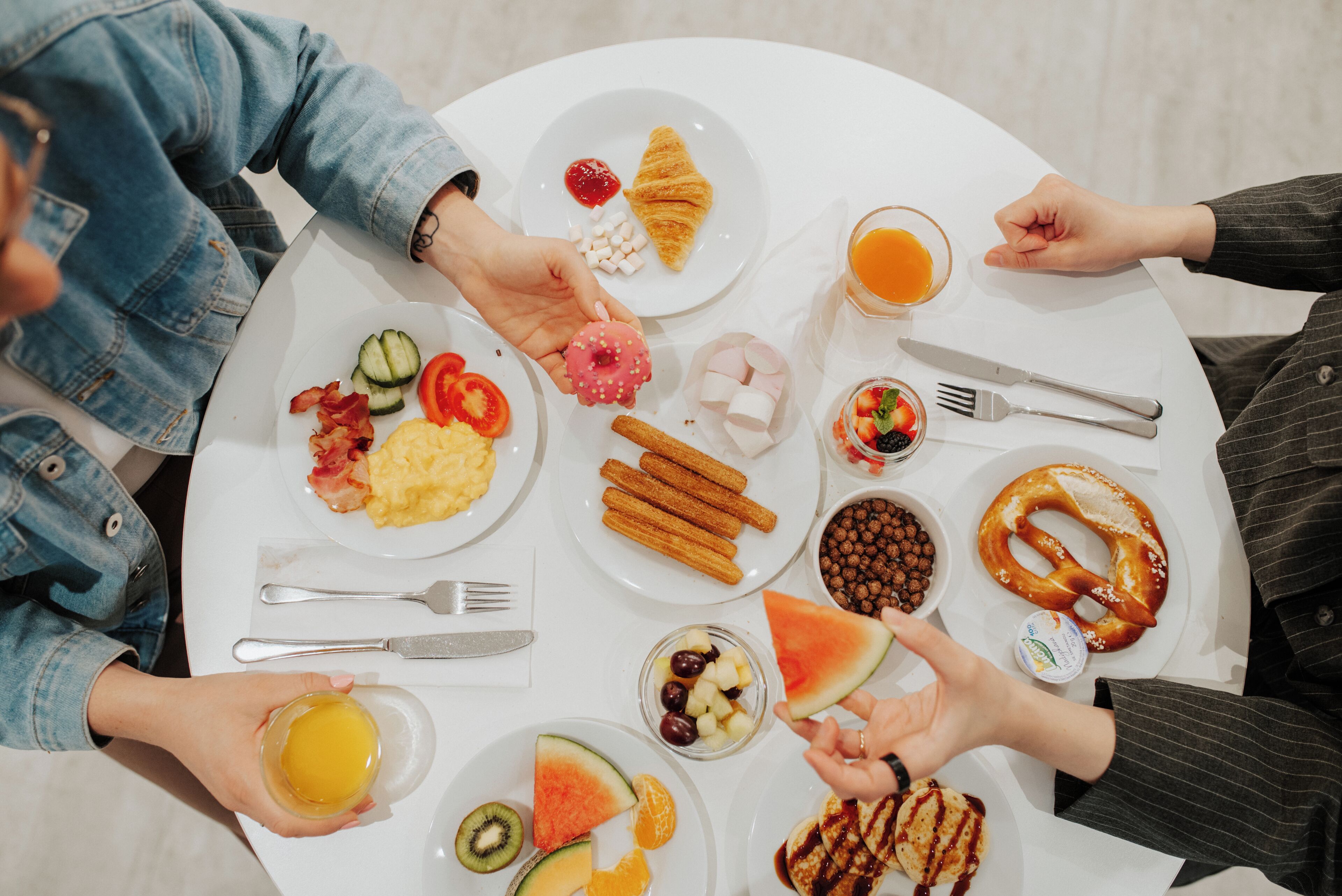A round table with various breakfast items including croissants, waffles, and fruit.