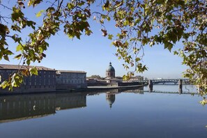 Stunning riverside views of a historic landmark with a dome structure, situated along the riverbank and connected by a bridge.