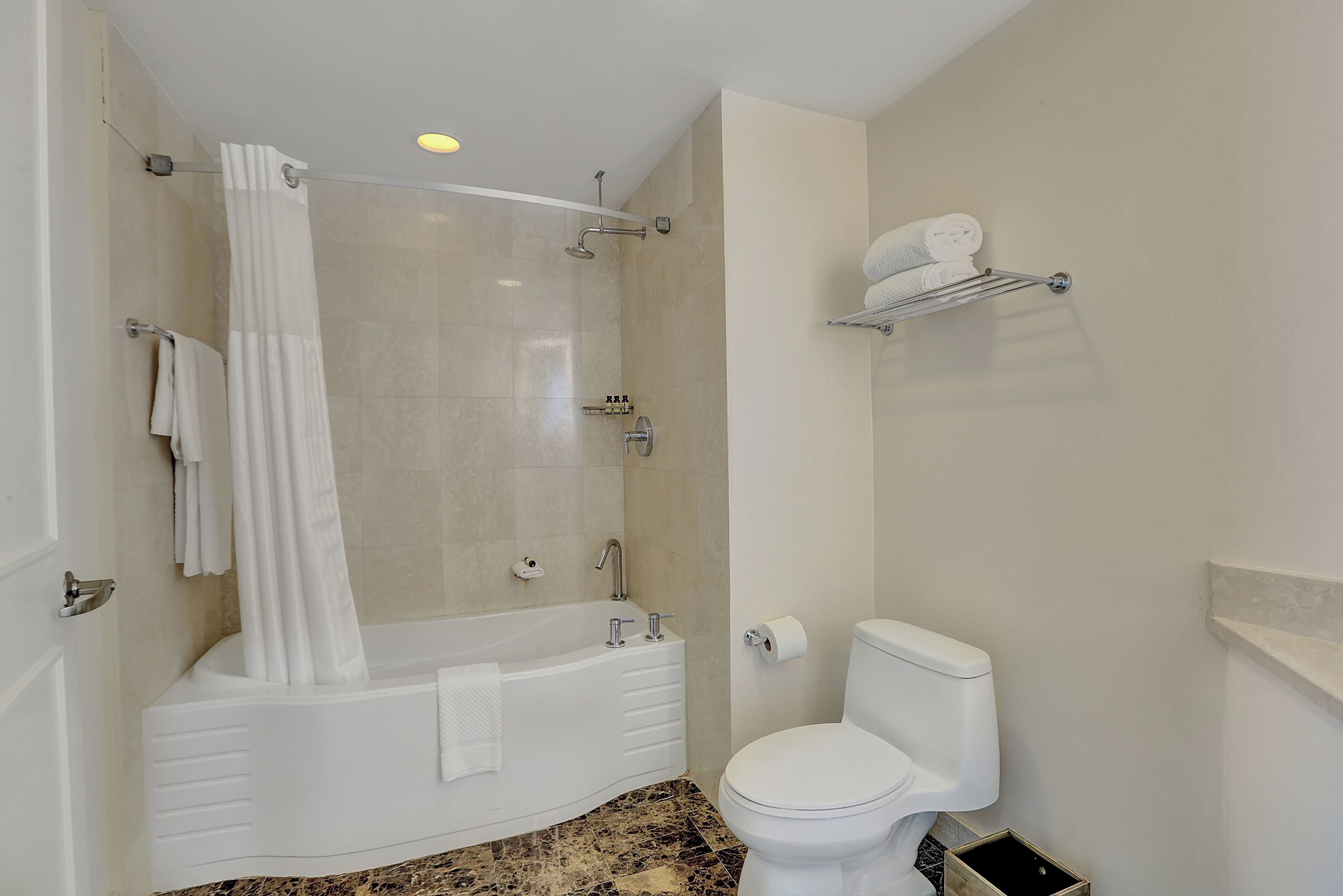 A bathroom with a bathtub, toilet, and shower curtain.